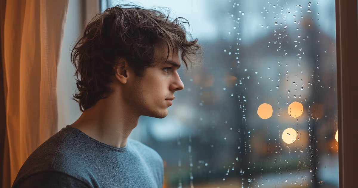 Man looking outside of window