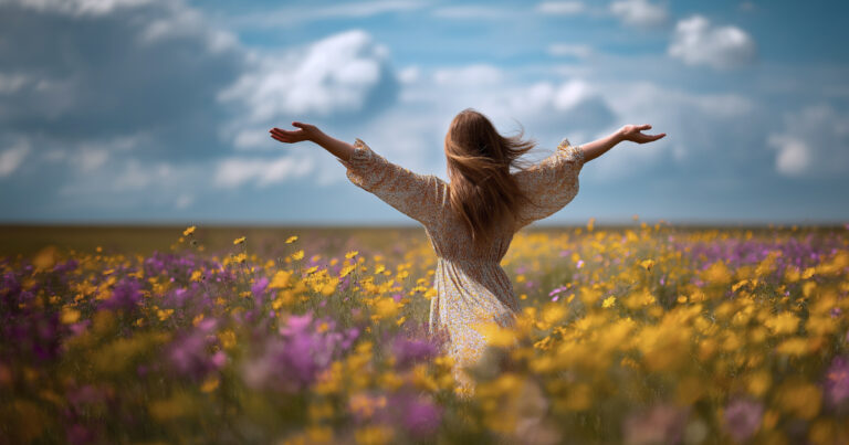 Woman with arms open in a field of flowers