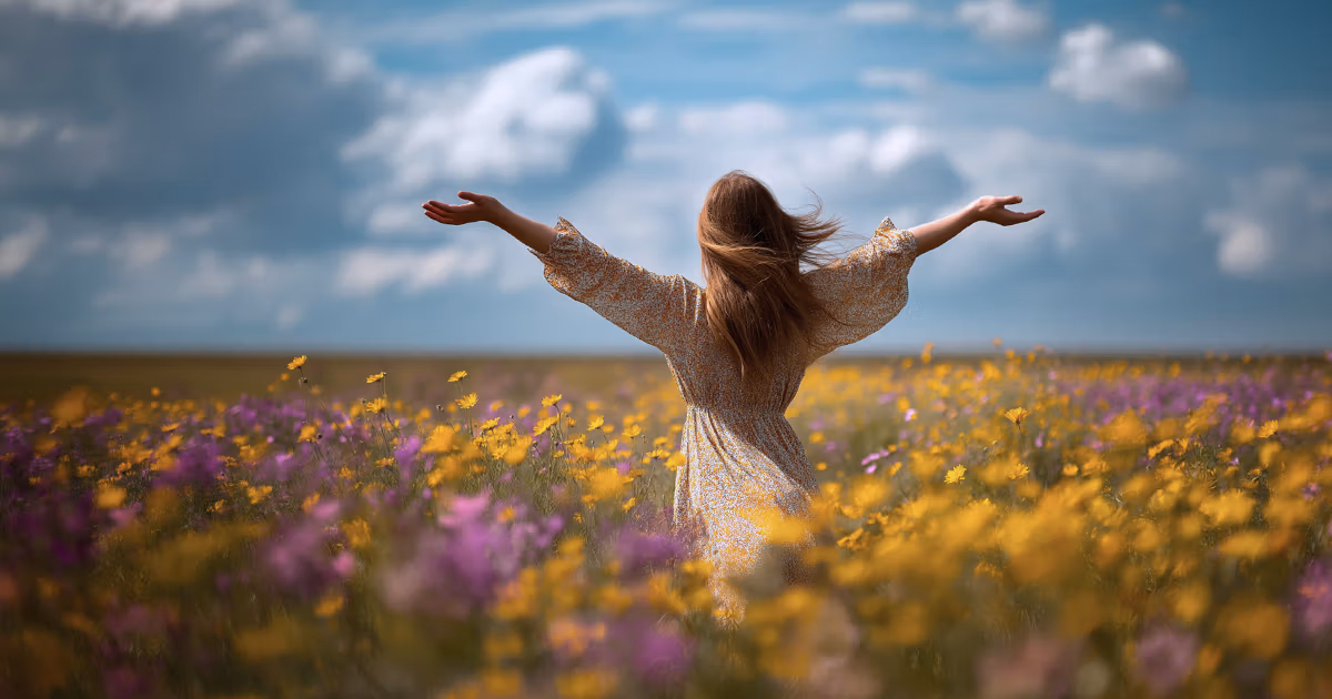 Woman with arms open in a field of flowers