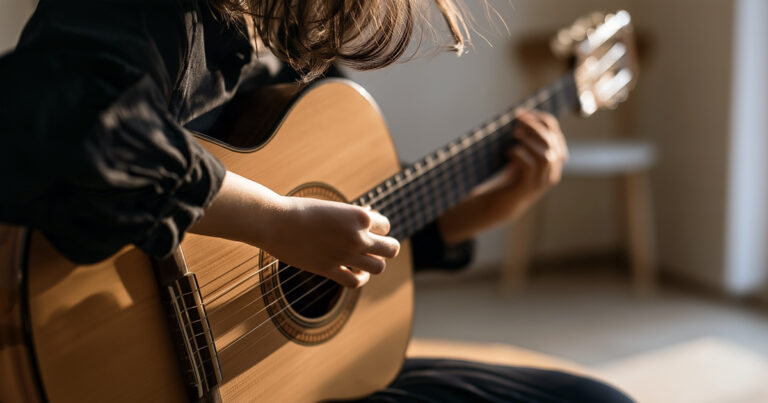 Person practising on an acoustic guitar